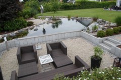 Schwimmteichanlage mit tieferliegender Terrasse mit Palisadeneinfassung