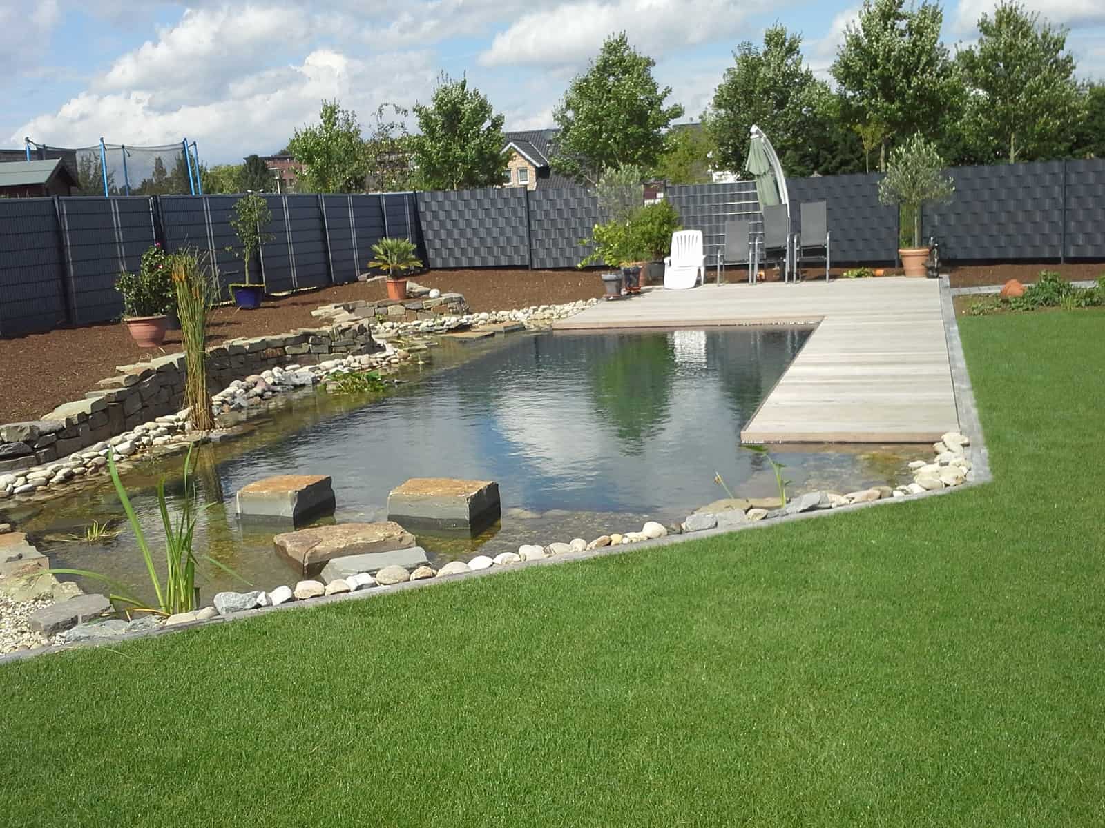 Schwimmteichanlage mit Holzterrasse und Natursteinmauer, Fertigrasen