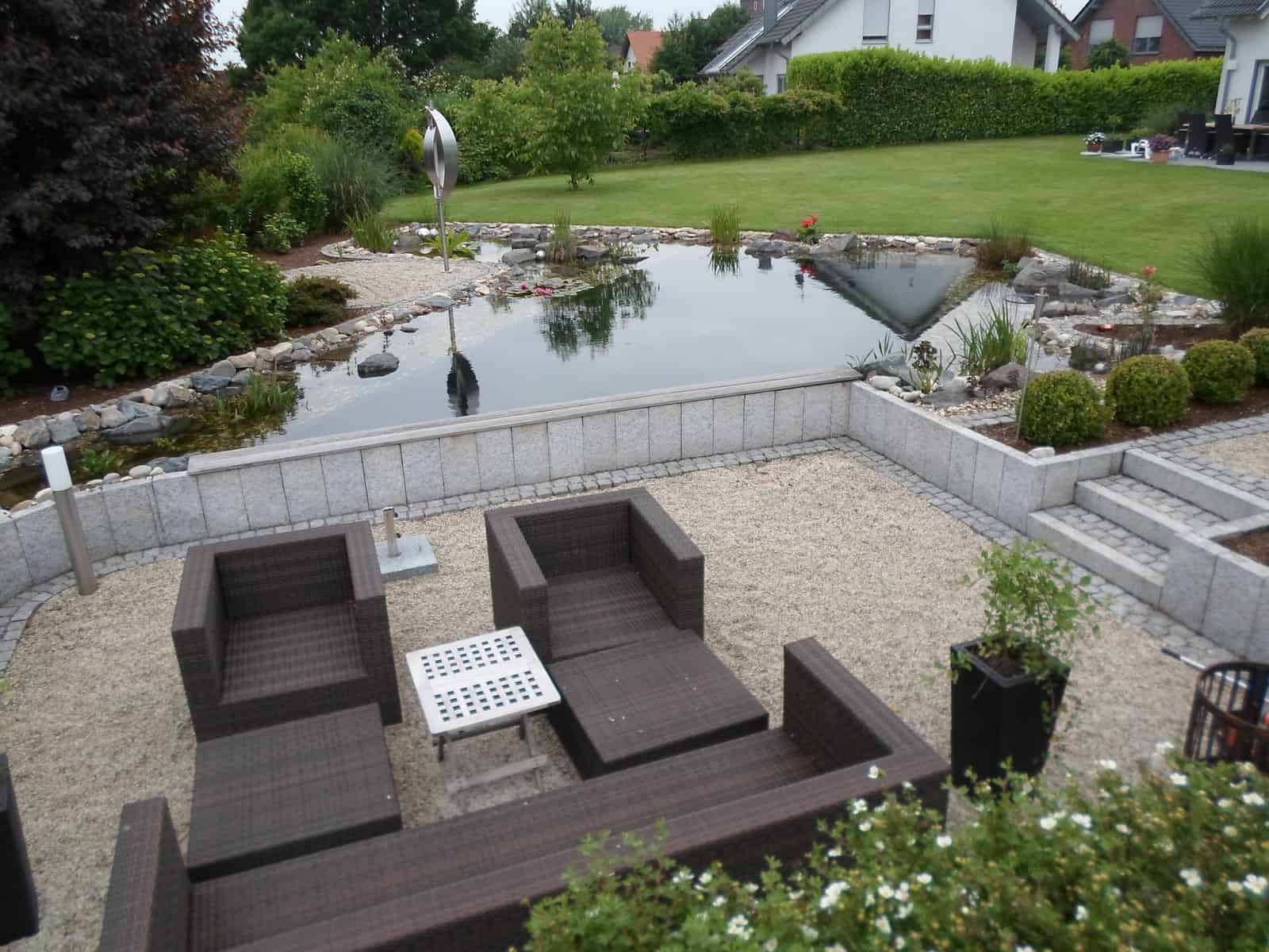 Schwimmteichanlage mit tieferliegender Terrasse mit Palisadeneinfassung